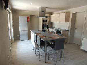 a kitchen with a large island with bar stools at le charme de la campagne in mesen