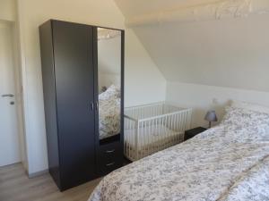 a bedroom with a large black cabinet next to a bed at le charme de la campagne in mesen