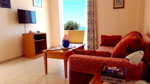 a living room with a couch and a table and a window at Creta Spirit in Plakias