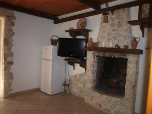 uma sala de estar com uma lareira de pedra e uma televisão em Villa Fralù em Mattinata