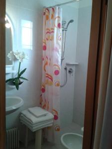 e bagno con doccia, servizi igienici e lavandino. di Hotel Paron a Bibione