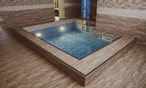 a swimming pool in a room with a wooden floor at Отель Шоколад in Barnaul
