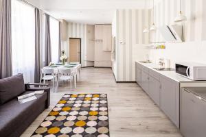 利維夫的住宿－#1 APARTMENT，厨房以及带沙发和桌子的客厅。