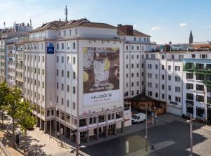 ein großes weißes Gebäude mit großer Werbung darauf in der Unterkunft Best Western Hotel zur Post in Bremen