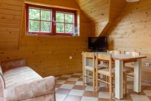 Cabaña con sala de estar con mesa y TV. en Apartments Petek, en Gornji Grad