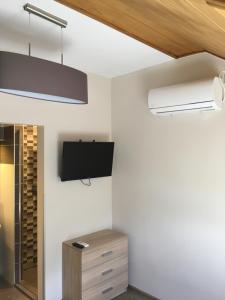 Habitación con TV de pantalla plana en la pared en Laza Vendégház, en Zamárdi