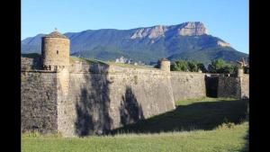 a large stone wall with a mountain in the background at Ático Jaca Ciudadela in Jaca