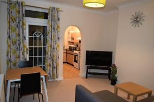 a living room with a television and a dining room at Kavig House in Lincoln