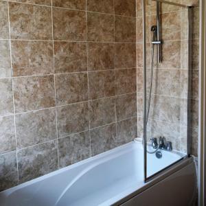 Das Bad ist mit einer Badewanne mit einer Dusche ausgestattet. in der Unterkunft Kavig House in Lincoln