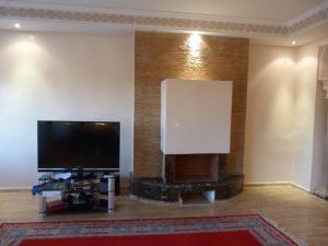 un soggiorno con una grande TV a schermo piatto a parete di Luxueux Appart Au Centre Ville a Fes