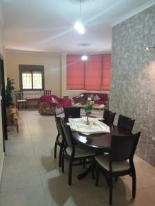 a dining room with a table and chairs at Honey Guesthouse in Jezzîne