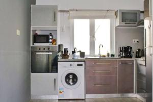 a kitchen with a washing machine and a microwave at A1 Dittany of Crête in Grand Baie