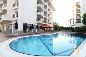 a swimming pool in a hotel with chairs and umbrellas at Sunway club otel in Marmaris