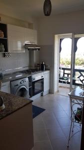 uma cozinha com um fogão e uma máquina de lavar louça em Marina Golf, Tanger Emplacement supérieur Juste à côté de la piscine em Asilah