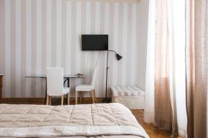 a bedroom with a bed and a desk with a television at b&b al parco in Trieste