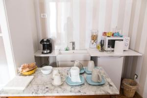a kitchen with a counter with cups and plates on it at b&b al parco in Trieste