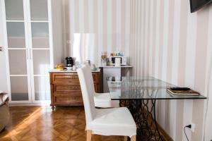 a dining room with a glass table and white chairs at b&b al parco in Trieste