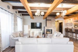 a living room with a white couch and a fireplace at Pillow House Tatras in Stará Lesná