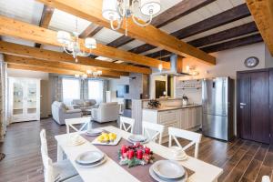 a kitchen and living room with wooden ceilings and a table and chairs at Pillow House Tatras in Stará Lesná