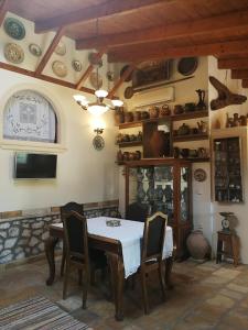 a dining room with a table and chairs and a shelf of dishes at Casa Victoria in Katokhórion