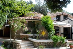 una casa con una parete di mantenimento e un giardino di Hotel Bosco Selene a Lanusei