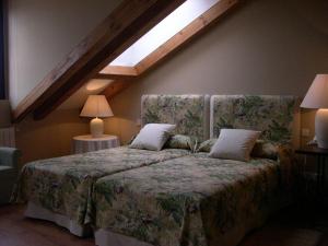 a hotel room with a bed and two lamps at Hotel Rural El Jardin de la Hilaria in Valsain