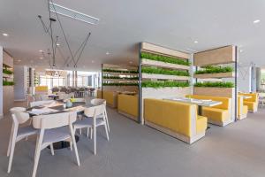 a restaurant with tables and chairs and plants on the wall at Garden Suites Park Plava Laguna in Poreč