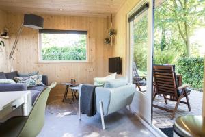 a tiny house with a living room and a patio at vakantiehuisje "ZUSJE" in Bruchterveld