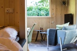 a room with a bed and a table and a window at vakantiehuisje "ZUSJE" in Bruchterveld +21 photos