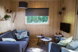 a living room with a blue couch and a tv at vakantiehuisje "ZUSJE" in Bruchterveld