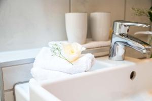 a bathroom sink with a towel with a rose on it at 5 Sterne Ferienwohnung am See in Böbing
