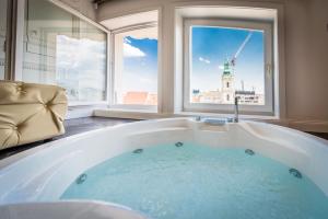 a large bath tub in a room with a window at Luxury Suites Down Town in Budapest