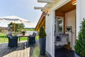 a patio with a table and chairs and an umbrella at 5 Sterne Ferienwohnung am See in Böbing