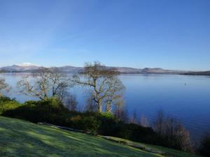 a view of a large body of water with trees at The Pipers No 7 Lomond Castle in Balloch