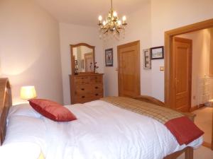 バロックにあるThe Pipers No 7 Lomond Castleのベッドルーム1室(白いベッド1台、赤い枕付)