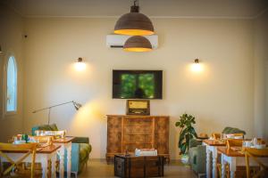 a living room with a couch and tables and a tv at Baglio Genovesi in Noto