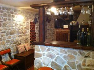 a bar in a restaurant with a stone wall at Vila Škrlec in Baška Voda