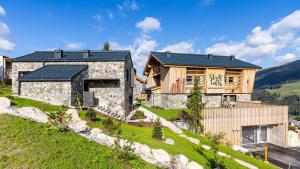 kamienny dom z czarnym dachem na wzgórzu w obiekcie Stadl Lofts Plattenalm - Premiumchalets - Zillertal - Tirol - Salzburg w mieście Krimml