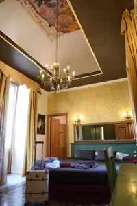 Un dormitorio con una cama grande y una lámpara de araña. en Hotel Federico II, en Lucera