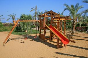 a wooden playground with a slide in the sand at Rivera Sharm Habiba Apartments in Sharm El Sheikh