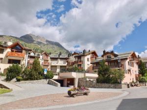 a town with houses and mountains in the background at Pizzet A6 in Silvaplana