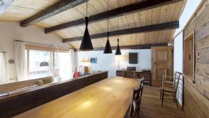 una sala da pranzo con un grande tavolo in legno e sedie di Fluor Hausteil a Zuoz