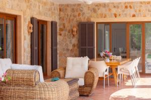 eine Terrasse mit Korbmöbeln sowie einem Tisch und Stühlen in der Unterkunft Villa Turquesa in Santa Margalida