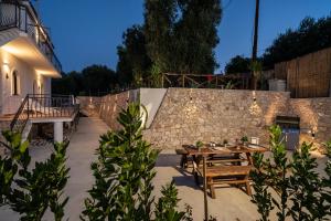 a patio with a wooden table and a stone wall at Borgo Canneto in Rodi Garganico