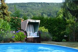 une chaise dans une cour avec piscine dans l'établissement Villa Sonnenseite Jonsdorf, à Jonsdorf