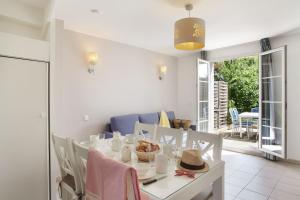 a white dining room with a table and chairs at Terres de France - Résidence de la Cabre d'Or in Cabriès