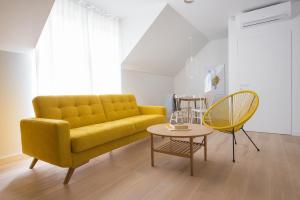 a living room with a yellow couch and a table at Colors Apartments Zator - tylko 10 minut piechotą od Energylandii in Zator