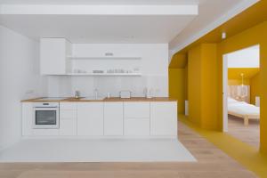 uma cozinha com electrodomésticos brancos e uma parede amarela em Colors Apartments Zator - tylko 10 minut piechotą od Energylandii em Zator