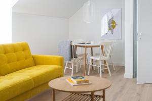 a living room with a yellow couch and a table at Colors Apartments Zator - tylko 10 minut piechotą od Energylandii in Zator