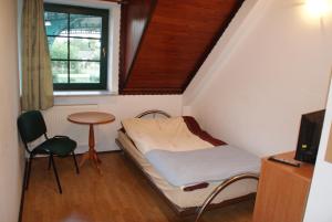 a small room with a bed and a table and a window at Motel Warmiaki Bed&breakfast in Jadów
